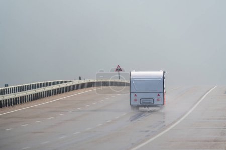 Photo for Caravan driving on the motorway in the rain. Motorway in the rain - Royalty Free Image