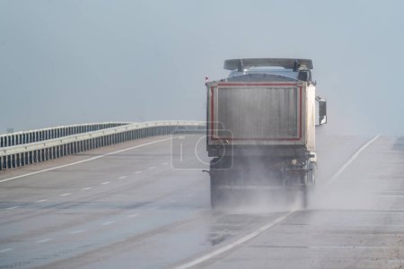 Sand lorry driving on motorway in the rain. Motorway in the rain.