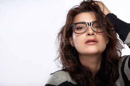 Foto de Close up attractive woman face with casual hairstyle, wearing fashion eyeglasses while looking at camera. Cool trendy eyewear portrait over white background - Imagen libre de derechos