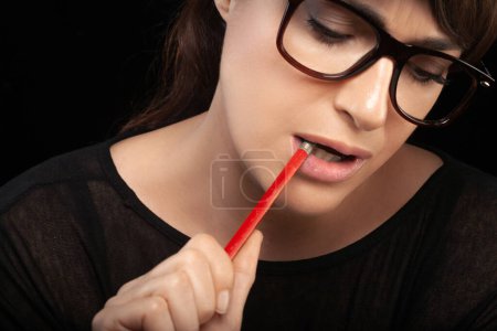 Photo for Business woman thinking. Thoughtful woman wearing glasses and biting pencil. Closeup portrait isolated on black - Royalty Free Image