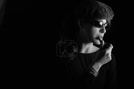 Photo for Beauty smoking an electronic pipe. Monochrome studio portrait isolated on black with copy space - Royalty Free Image