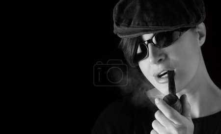 Photo for Atractive hipster girl smoking a vintage wooden pipe. Panorama banner studio portrait isolated on black background with copyspace - Royalty Free Image