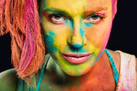 Foto de Misteriosa mujer sensual cubierta de polvo de color arco iris utilizado para celebrar los colores festival Holi. Concepto primavera belleza - Imagen libre de derechos