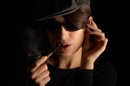 Téléchargez les photos : Woman smoking pipe. Closeup studio portrait isolated on black background with copyspace - en image libre de droit