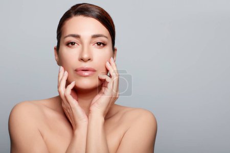 Photo for Beauty and Skincare Concept. Mature natural Woman with healthy glowing skin. Studio portrait on gray background with copy space - Royalty Free Image