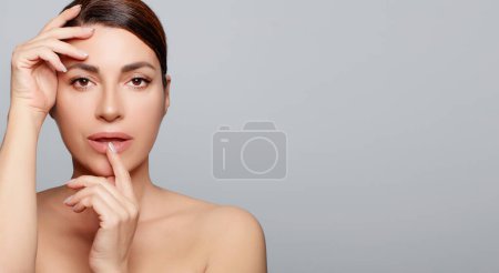 Photo for Beauty face. Beautiful latin woman with natural makeup and healthy glowing skin. Studio portrait on gray background with copy space - Royalty Free Image