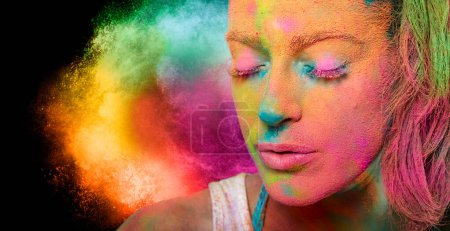 Foto de Beautiful sensual woman covered in rainbow colored powder celebrating Holi Festival in a beauty spring concept. Gorgeous young woman having fun with colorful powder - Imagen libre de derechos