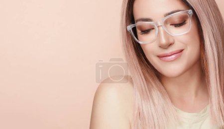 Photo for Woman in fashionable clear glasses posing in studio. Fashion eyewear and clear vision concept. Close-up portrait over beige background with copy space - Royalty Free Image