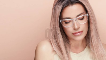 Photo for Close up attractive woman with casual hairstyle, wearing fashion eyeglasses. Cool trendy eyewear portrait isolated on beigebackground with copyspace. - Royalty Free Image