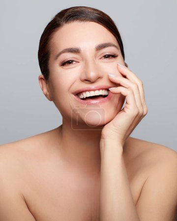 Photo for Beauty and Skincare Concept. Smiling natural woman withVertical studio portrait on grey background - Royalty Free Image