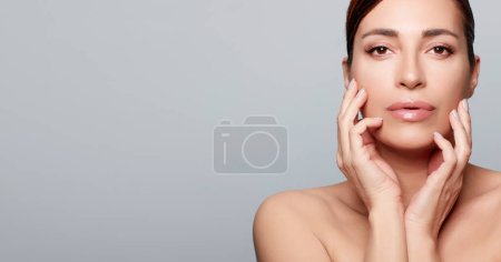 Photo for Beauty and Skincare Concept. Mature natural woman with healthy glowing skin. Studio portrait on gray background with copy space - Royalty Free Image
