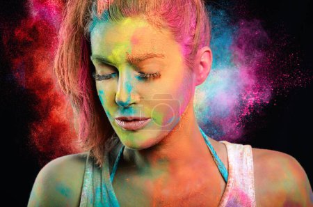Photo for Woman covered in colored powder with a rainbow color explosion in the background. - Royalty Free Image