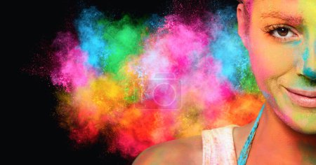 Foto de Mujer joven cubierta de polvo de color con una explosión de color arco iris en el fondo. Festival de colores concepto. Banner panorámico con espacio de copia. - Imagen libre de derechos