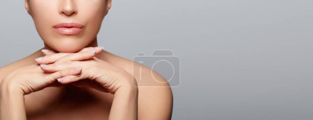 Photo for Beautiful woman with a flawless fresh clean skin posing in studio. Beauty and skin care concept. Close up cropped portrait on grey background with copy space - Royalty Free Image