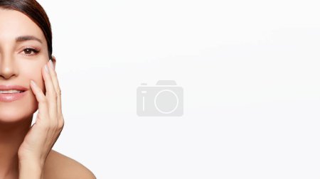 Foto de Cuidado de la piel saludable. Hermosa mujer de mediana edad con una tez luminosa e hidratada y maquillaje natural que mejora su aspecto radiante y juvenil aislada sobre un fondo blanco con espacio para copiar. - Imagen libre de derechos