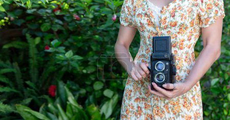Foto de Mujer tomando fotos con una cámara retro al aire libre. Banner retrato recortado con espacio de copia - Imagen libre de derechos