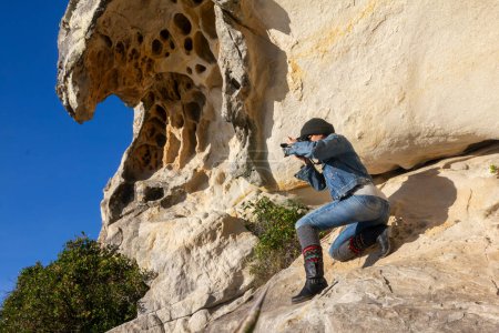Téléchargez les photos : Femme photographe capture des formations rocheuses impressionnantes dans un paysage accidenté. copyspace - en image libre de droit