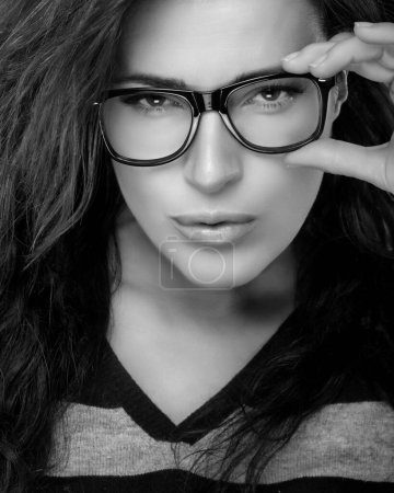 Téléchargez les photos : Close up Gorgeous Woman Holding her Eyeglasses While Looking at Camera. Cool Trendy Eyewear Portrait isolated on Black Background - en image libre de droit