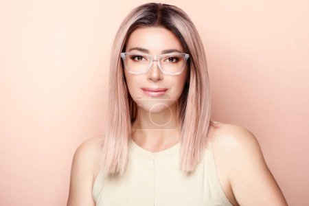 Photo for Radiant woman with flawless skin and stylish glasses exudes confidence. Her vibrant smile and lustrous hair enhance her youthful allure. A captivating portrait of beauty and impeccable vision care. - Royalty Free Image