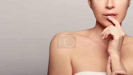 Photo for A radiant young woman with fresh, healthy skin in a calming gray background. She embodies the beauty industry's self-care habits and rejuvenation. With copyspace. - Royalty Free Image