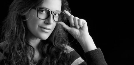 Photo for A young woman with long hair and fashionable glasses. Her black and white makeup contributes to her unique monochrome look. A fashion portrait that captures her fashion sense and caring vision of her. - Royalty Free Image