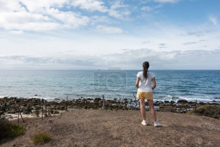 Photo for A confident woman enjoying a self-soothing vacation by the ocean, surrounded by nature's beauty. Tranquility and self-expression captured candidly on a serene beach. - Royalty Free Image