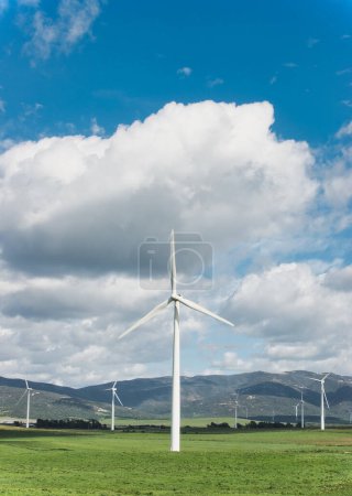Foto de Turbinas eólicas de pie en un campo, nubes por encima de la señal de energía sostenible y un futuro más limpio. - Imagen libre de derechos