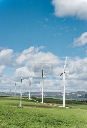 Photo for Row of wind turbines against clear blue sky, representing renewable energy and sustainability. - Royalty Free Image