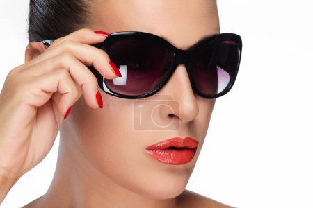 Close-up of a beautiful woman showcasing fashionable oversized sunglasses with a flawless makeup look. Perfect for beauty and fashion themes. Isolated on white.