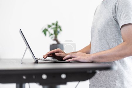 Photo for Asian man working at standing desk - Royalty Free Image