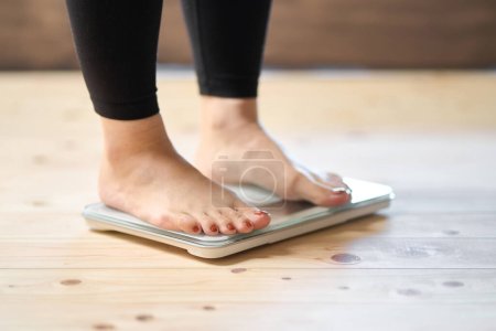 Photo for Feet of an Asian woman on a weight scale - Royalty Free Image