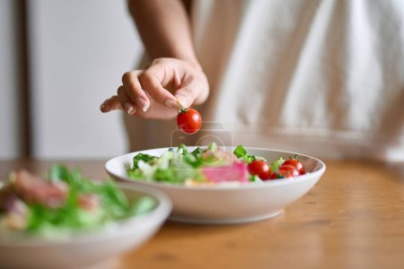 Téléchargez les photos : Une main de femme servant une salade - en image libre de droit