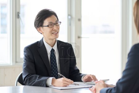 Foto de Asian male tax accountant receiving tax consultation - Imagen libre de derechos