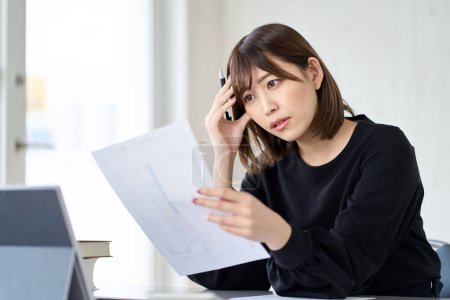 Photo for Asian woman worried about tax return - Royalty Free Image
