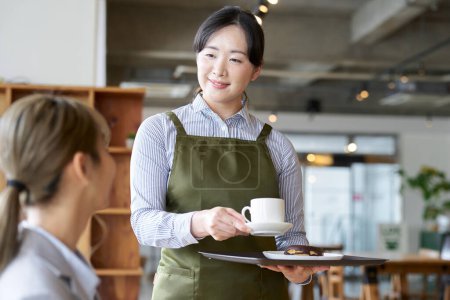 Téléchargez les photos : Asiatique femme commis travaillant dans un café - en image libre de droit