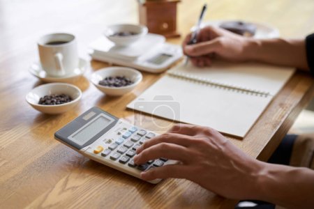 Photo for Asian man calculating the cost of coffee - Royalty Free Image