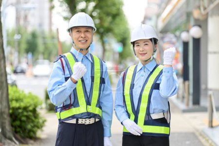 Photo for Asian male and female security guards doing fist pumps - Royalty Free Image