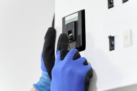 Foto de De la mano de un electricista que opera un interruptor - Imagen libre de derechos