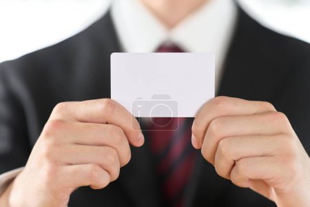 Mano del hombre de negocios sosteniendo una tarjeta normal