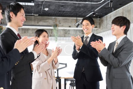 Asian business person applauding with his team