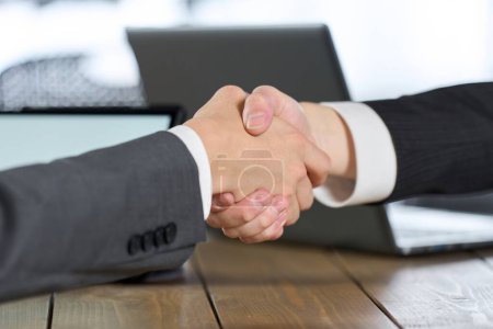 Geschäftsmann unterschreibt Vertrag und schüttelt Hände