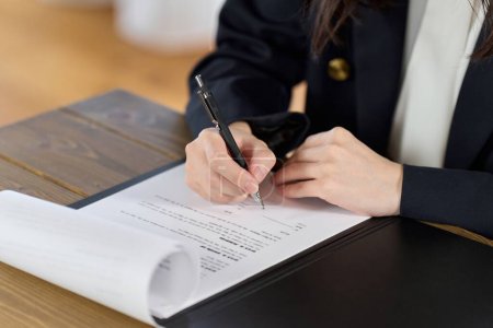 Téléchargez les photos : Femme d'affaires signant un contrat - en image libre de droit