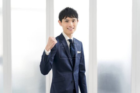 A businessman wearing a custom suit and doing a fist pump