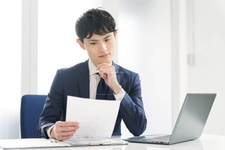 Asian businessman examining work documents