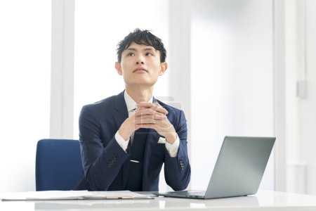 Asian businessman thinking while working