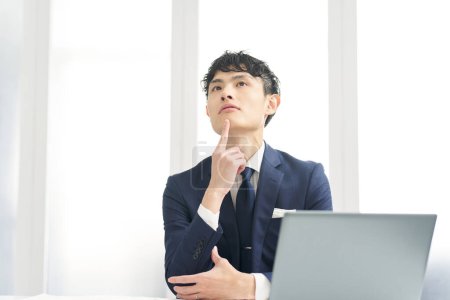 Asian businessman thinking while working