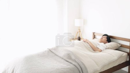 Foto de Asiático hombre durmiendo en un brillante habitación - Imagen libre de derechos
