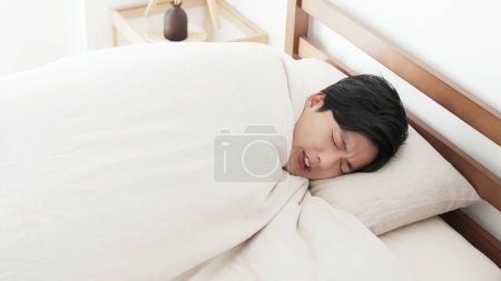 Foto de Un hombre se siente frío en la cama - Imagen libre de derechos