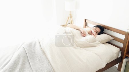 Un homme mesure sa température avec un thermomètre pendant qu'il dort