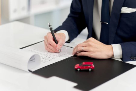 Homme d'affaires signant un contrat de voiture